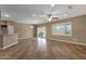 Bright living room with neutral walls, ceiling fan, tiled floors, slider doors, and window with plantation shutters at 16525 W Tranquility Ln, Surprise, AZ 85387