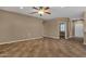 Spacious living room with tile flooring, ceiling fan, neutral walls, and open layout, perfect for relaxation and entertaining at 16525 W Tranquility Ln, Surprise, AZ 85387
