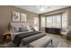 Serene main bedroom features a large bay window, plush bed, soft color palette, and ceiling fan at 16525 W Tranquility Ln, Surprise, AZ 85387