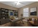 Modern home office with stylish built-in shelving, a large desk, and an inviting chair, perfect for a productive workspace at 16525 W Tranquility Ln, Surprise, AZ 85387