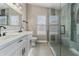 Modern bathroom with double sinks, white cabinets, black hardware, and a walk-in shower at 1672 W Butler Dr, Chandler, AZ 85224