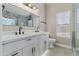 Bathroom featuring double sinks with black hardware, and walk-in shower with glass door at 1672 W Butler Dr, Chandler, AZ 85224