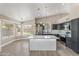 Open-concept kitchen featuring an island with seating, stainless steel appliances, dark cabinets, and ample natural light at 1672 W Butler Dr, Chandler, AZ 85224