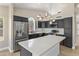 Stylish kitchen showcasing stainless steel appliances, a center island with quartz countertop, and dark cabinetry at 1672 W Butler Dr, Chandler, AZ 85224