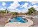 Backyard with a pool featuring rock waterfall features and desert landscaping, surrounded by privacy fencing at 1672 W Butler Dr, Chandler, AZ 85224