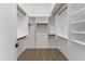 Bright walk-in closet features built-in shelving, hanging rods and wood-look flooring at 1672 W Butler Dr, Chandler, AZ 85224