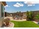 A luxurious backyard features a manicured lawn, outdoor seating, and a decorative water feature at 16756 S 181St Ln, Goodyear, AZ 85338