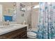 Upgraded bathroom with elegant vanity, stylish fixtures, and a tub-shower combo with decorative curtain at 16756 S 181St Ln, Goodyear, AZ 85338