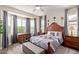 Comfortable bedroom with wood floors, ceiling fan, stylish furnishings, and large windows for natural light at 16756 S 181St Ln, Goodyear, AZ 85338
