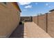 Side yard with gravel and pavers leads to a backyard featuring a hot tub and privacy wall at 16756 S 181St Ln, Goodyear, AZ 85338