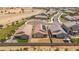 An aerial view showing a residential neighborhood with surrounding desert landscape and a drainage canal at 16824 W Alice Ave, Waddell, AZ 85355