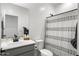 Bright bathroom featuring a gray vanity, a shower-tub combo, and a large mirror at 16824 W Alice Ave, Waddell, AZ 85355