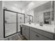 Spacious bathroom with double vanity, large mirror, and a modern glass enclosed shower at 16824 W Alice Ave, Waddell, AZ 85355