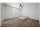 Minimalist bedroom with neutral carpet, a ceiling fan and a simple bed and linens at 16824 W Alice Ave, Waddell, AZ 85355
