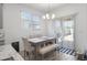 Dining area with a rustic wood table set and a sliding glass door to the backyard at 16824 W Alice Ave, Waddell, AZ 85355