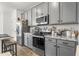 Contemporary kitchen with granite countertops, stainless steel appliances, and gray cabinetry at 16824 W Alice Ave, Waddell, AZ 85355