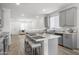 Gray kitchen with granite countertops, island with seating, and open floor plan to living area at 16824 W Alice Ave, Waddell, AZ 85355