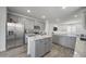 This open kitchen has stainless steel appliances, gray cabinets, granite counters, and an island at 16824 W Alice Ave, Waddell, AZ 85355