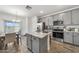 Stylish kitchen with a center island, stainless steel appliances, and wood-look flooring at 16824 W Alice Ave, Waddell, AZ 85355