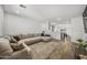 Bright living room with neutral tones, wood-look floors, and a comfortable sectional sofa at 16824 W Alice Ave, Waddell, AZ 85355