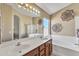 Bright bathroom with double sinks, soaking tub, and tiled shower at 17425 N 1St Dr, Phoenix, AZ 85023