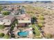 Aerial view of the home and community with a sparkling pool, covered patio, and scenic desert landscape at 18121 E San Luis Dr, Gold Canyon, AZ 85118
