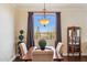Formal dining room with a backyard view, featuring decorative chandelier and dark wood flooring at 18121 E San Luis Dr, Gold Canyon, AZ 85118
