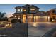 Two-story home featuring three-car garage, red tile roof, desert landscaping, and a covered porch entry at 18121 E San Luis Dr, Gold Canyon, AZ 85118