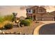 Home exterior with desert landscaping, shrubbery, a three-car garage and a red tile roof at 18121 E San Luis Dr, Gold Canyon, AZ 85118