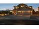 Inviting two-story home with a three-car garage and well-lit driveway at twilight at 18121 E San Luis Dr, Gold Canyon, AZ 85118