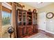 Elegant home office with a grand display cabinet and natural light from the window at 18121 E San Luis Dr, Gold Canyon, AZ 85118