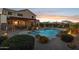 Outdoor pool with desert landscaping, lighting, and a covered patio creates a backyard oasis at 18121 E San Luis Dr, Gold Canyon, AZ 85118