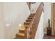 Carpeted staircase with a wood banister, alongside a side table and plant at 18121 E San Luis Dr, Gold Canyon, AZ 85118