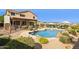 Stunning backyard featuring a sparkling pool, covered patio, and lush landscaping, ideal for relaxation and entertainment at 18121 E San Luis Dr, Gold Canyon, AZ 85118