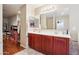 Bathroom featuring double sinks, cherry cabinets, and a large mirror at 19182 N Smith Dr, Maricopa, AZ 85139