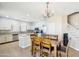 Open kitchen area featuring tile floors, an island, stainless appliances, and a wooden table with chairs at 19182 N Smith Dr, Maricopa, AZ 85139