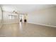A spacious living room featuring beige tiling, a ceiling fan, and an archway at 19182 N Smith Dr, Maricopa, AZ 85139