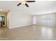Large living room with tile flooring, ceiling fan, and multiple windows providing natural light at 19182 N Smith Dr, Maricopa, AZ 85139