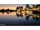 Scenic community pond featuring illuminated trees and a small waterfall at dusk creating a tranquil and picturesque setting at 19182 N Smith Dr, Maricopa, AZ 85139