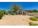 Large desert landscaped backyard featuring block wall and mature tree for shade and privacy at 20409 W Thayer St, Buckeye, AZ 85396