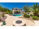 Inviting backyard oasis with a sparkling pool, spa, fire pit, covered patio, and lush landscaping at 20409 W Thayer St, Buckeye, AZ 85396