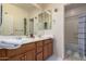 Bathroom with dual sinks, wooden cabinets, and shower-tub combination at 20409 W Thayer St, Buckeye, AZ 85396