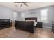 Primary bedroom boasts natural light, wood floors, ceiling fan and modern decor at 20409 W Thayer St, Buckeye, AZ 85396