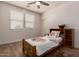 Bright bedroom with a cozy bed, natural light from large windows, and modern ceiling fan at 20409 W Thayer St, Buckeye, AZ 85396