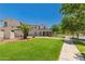 Spacious two-story home with a well-maintained lawn, mature trees, and a circular driveway, offering curb appeal and ample parking at 20409 W Thayer St, Buckeye, AZ 85396
