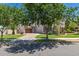 Inviting two-story home with a paved driveway leading to a garage, lush green lawn, and mature trees, showcasing its serene setting at 20409 W Thayer St, Buckeye, AZ 85396