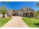 Expansive two-story home with a brick driveway, manicured lawn, and mature trees, highlighting its grand presence and welcoming atmosphere at 20409 W Thayer St, Buckeye, AZ 85396
