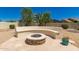 Beautiful backyard firepit with stone bench and desert landscaping at 20409 W Thayer St, Buckeye, AZ 85396