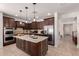 Spacious kitchen features dark wood cabinets, granite counters, stainless appliances and wine storage at 20409 W Thayer St, Buckeye, AZ 85396