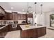 Gourmet kitchen featuring an island, stainless steel appliances, and dark wood cabinetry at 20409 W Thayer St, Buckeye, AZ 85396